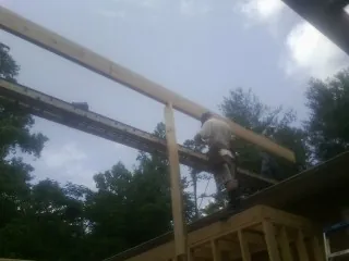 Carpenter setting a ridge beam over a new addition frame — Ice Dam Removal by Roofing Brothers in Secaucus