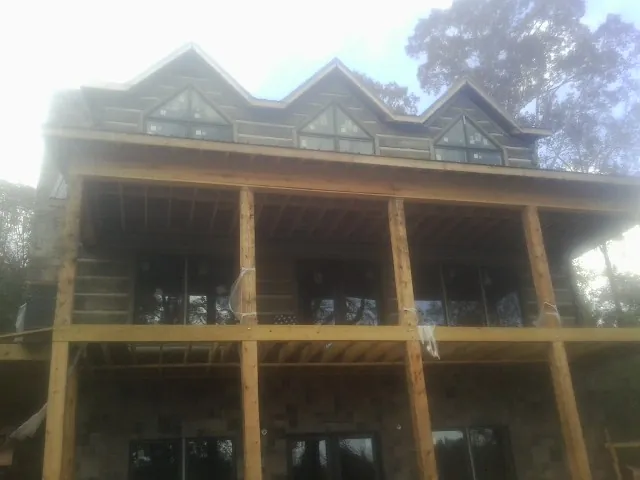 Dormers and porch framing on a large log home under construction — Roof Coating work by our crew in Secaucus
