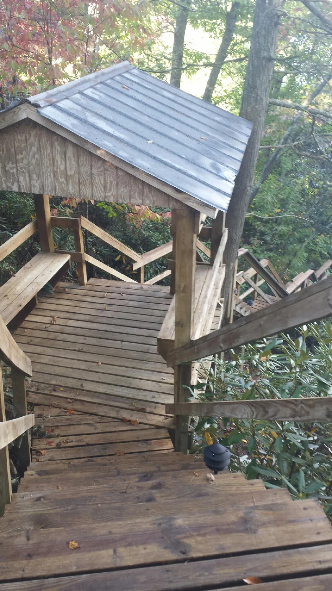 Metal roofed shelter over wooden steps on a wooded walkway — Skylight Repair & Installation work by our crew in Secaucus