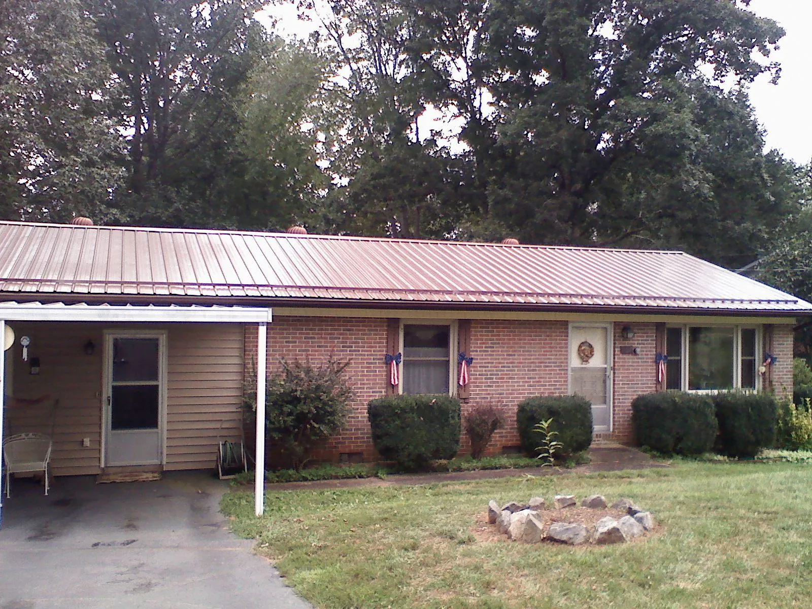 Bronze metal roof and carport on a brick ranch home — Roof Repair work by our crew in Secaucus
